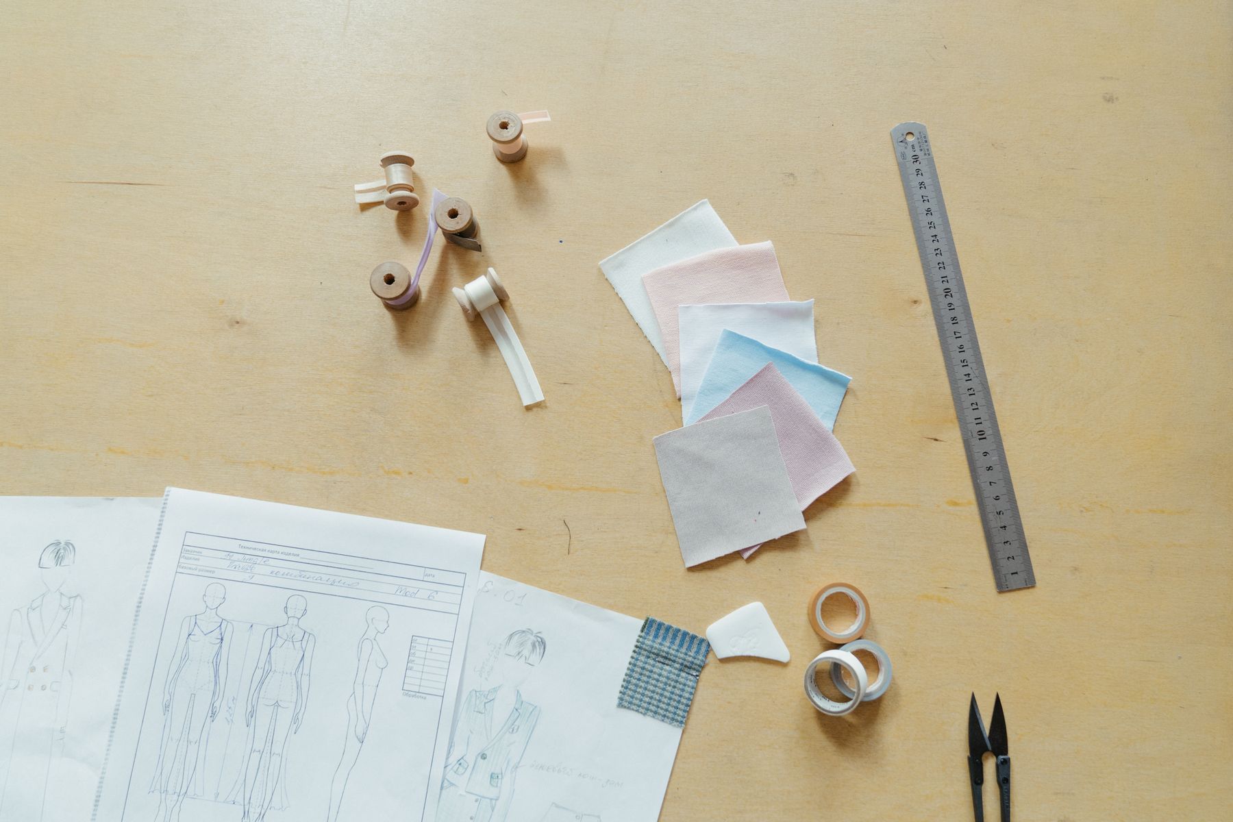 Fashion sketches, fabric swatches and development tools arranged on a worktable