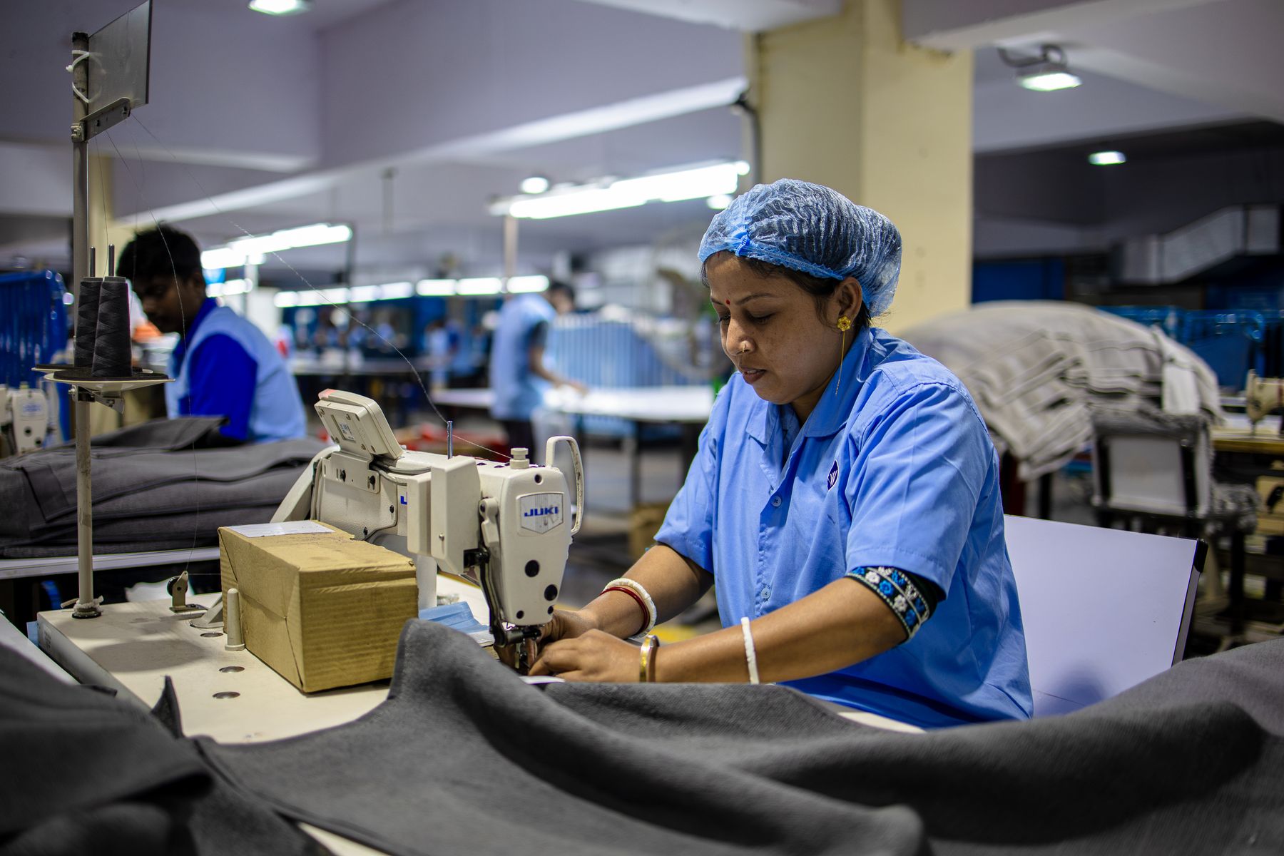 Garment operator sewing apparel on an organised production floor